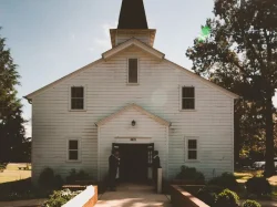 Two Person Standing Near White Church